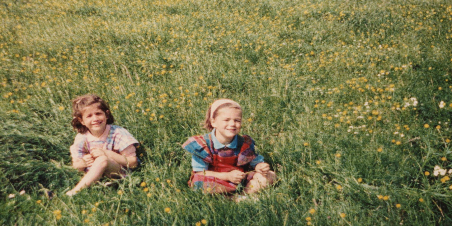Linda et Nadine enfants, assises dans un champ de fleurs